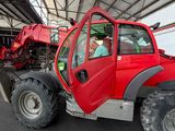 a large red tractor parked under a tent