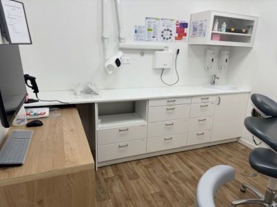a desk with a computer and a chair in a room