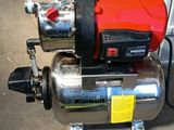 an image of a red and black water pump sitting on top of a metal container
