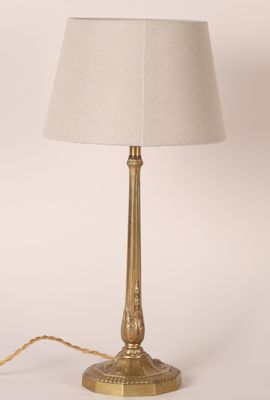 une lampe de table en laiton avec un abat-jour blanc sur fond blanc