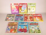 several children ' s books are lined up on a white surface
