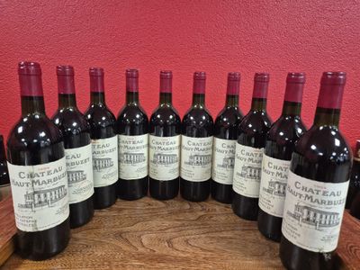 six bouteilles de vin rouge sont alignées sur une table en bois