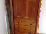 a wooden cabinet with a door open in a room