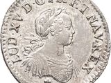 a silver coin with an image of a woman wearing a headdress