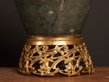 a green vase sitting on top of a wooden table