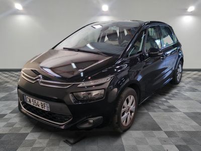 La Citroën noire est garée sur un sol en damier dans un garage