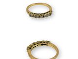 three gold rings with black diamonds on a white background