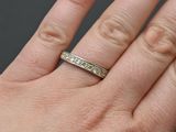 a woman ' s hand with a wedding ring on it