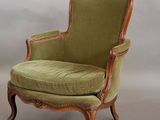a chair with a green upholstered seat and a wooden frame