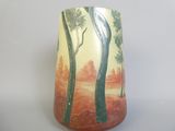 un vase avec un tableau posé sur une table