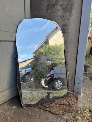 a mirror sitting on the ground next to a motorcycle