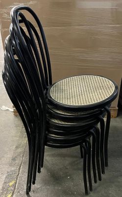 four black chairs sitting next to each other on the sidewalk