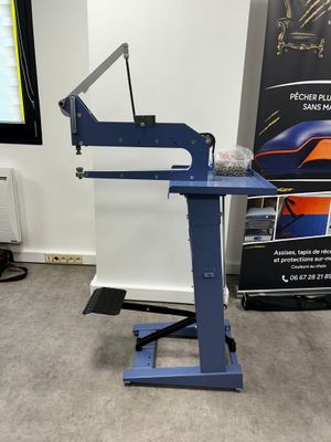 the machine is sitting on a stand in front of a poster
