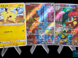 Trois cartes Pokémon sont exposées sur un présentoir devant un fond noir.