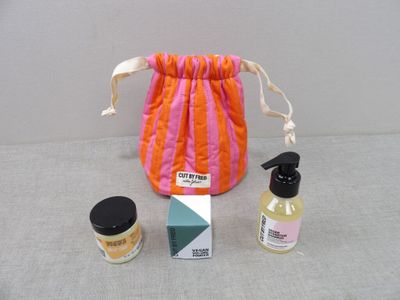un petit sac contenant un flacon de liquide et un petit flacon de lotion