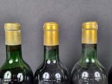 bottles of wine are lined up on a shelf in a row