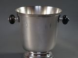a silver ice bucket with two black balls in it