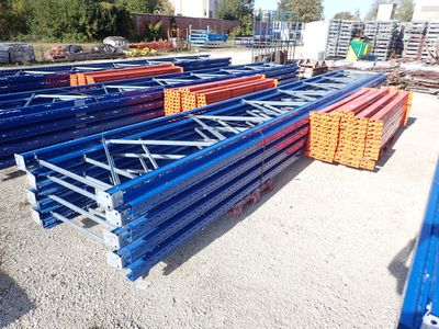 several piles of blue and orange steel beams in a yard