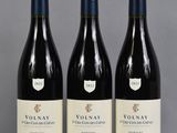 trois bouteilles de vin sont alignées sur une table