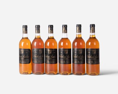 six bottles of whisky lined up on a white surface