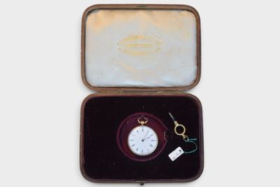a small box with a pocket watch inside of it