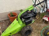 a green lawn mower that is sitting in the grass