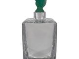 an image of a bottle of perfume with a green top