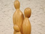 a wooden sculpture of two people and a child