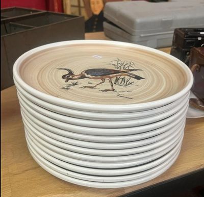 une pile d'assiettes ornées d'un oiseau, posée sur une table