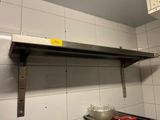 a metal shelf with a sign on it in a kitchen