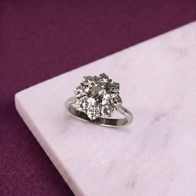 une photo d'une bague en diamant posée sur une dalle de marbre
