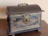 a small metal box sitting on a wooden table