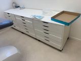 une commode blanche avec des tiroirs et une boîte posée dessus