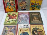 several children ' s books are lined up on a white surface