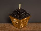a small gold vase with a bird on top of it
