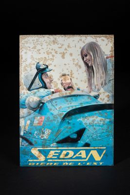 une boîte bleue sur laquelle figure l'image d'une femme et d'un homme dans une voiture