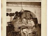 a black and white photo of a group of people sitting at a table