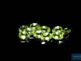 a close up of a bunch of green gems on a black surface