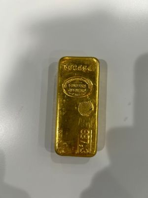 a close up of a gold bar on a white surface