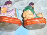 deux figurines représentant un homme et une femme assis sur un lit