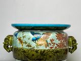 un vase bleu et vert orné d'un motif représentant un oiseau