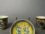 three chinese porcelain cups and a plate with a dragon design