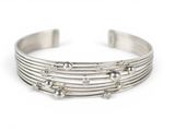 a close up of a silver bracelet on a white background