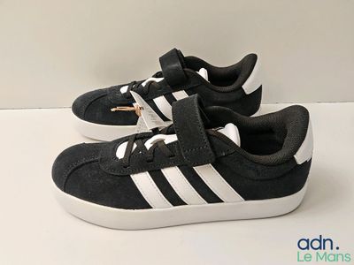 a pair of black and white shoes on a white surface