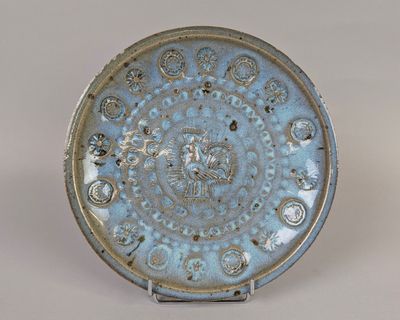 une assiette bleue décorée d'un motif, posée sur une table
