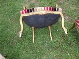 a chair that is sitting in the grass with a lot of bottles on it
