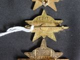 three gold star shaped badges on a black background