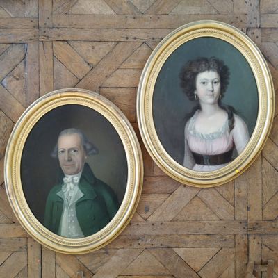 deux portraits d'un homme et d'une femme accrochés au mur