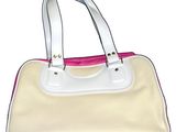 a white purse with pink handles on a white surface
