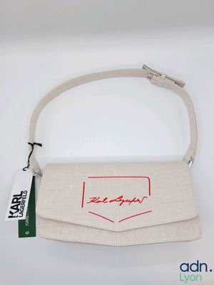 une image représentant un sac à main blanc orné d'un logo rouge
